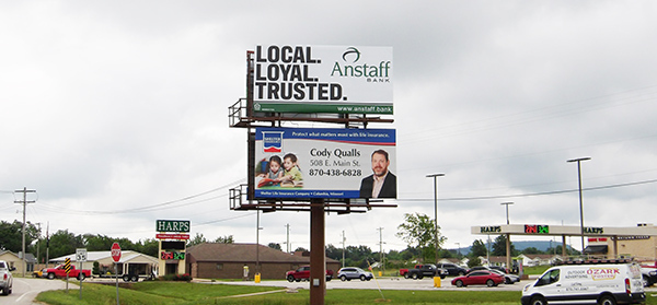 2 stacked billboards for Anstaff Bank and Shelter Insurance in front of Harrison Harps grocery store